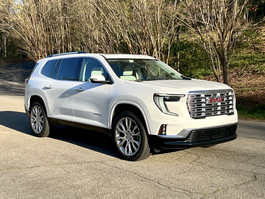 2025 GMC Acadia Denali driving on the road during a test drive showing road presence and handling