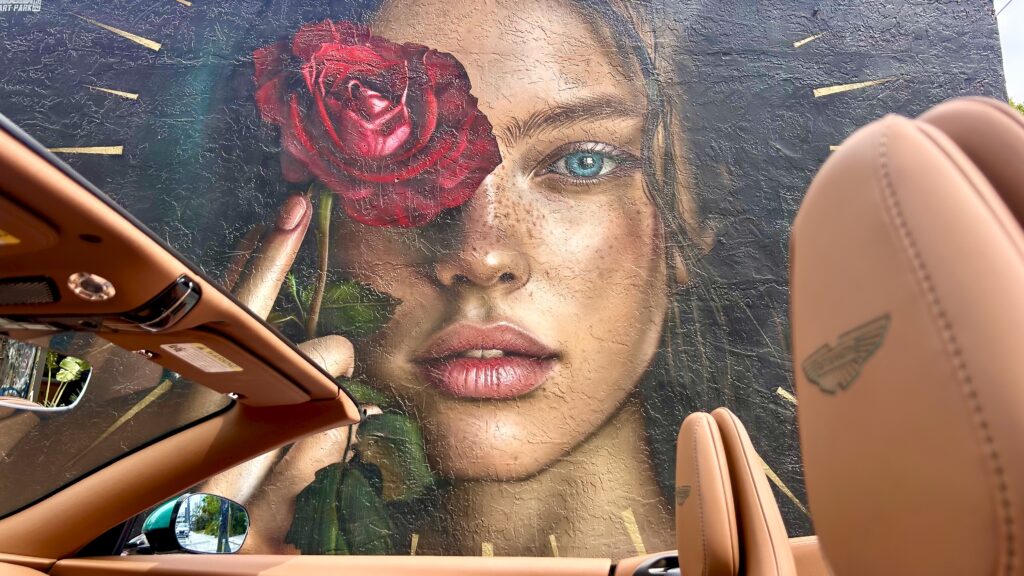 Aston Martin DB12 Volante luxury convertible photographed in Miami's Wynwood district, surrounded by vibrant street art and murals