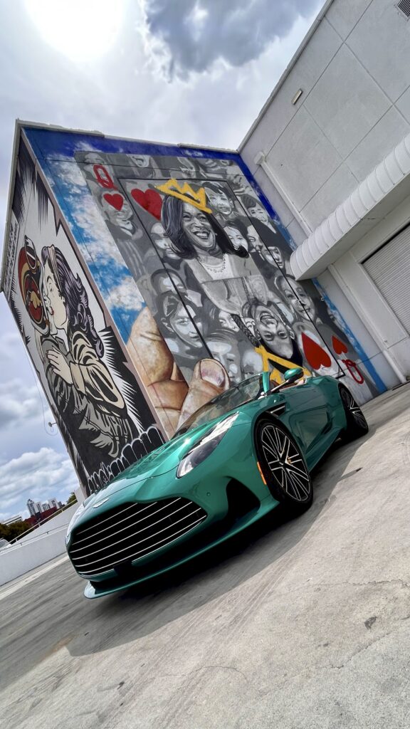 Aston Martin DB12 Volante luxury convertible photographed in Miami's Wynwood district, surrounded by vibrant street art and murals