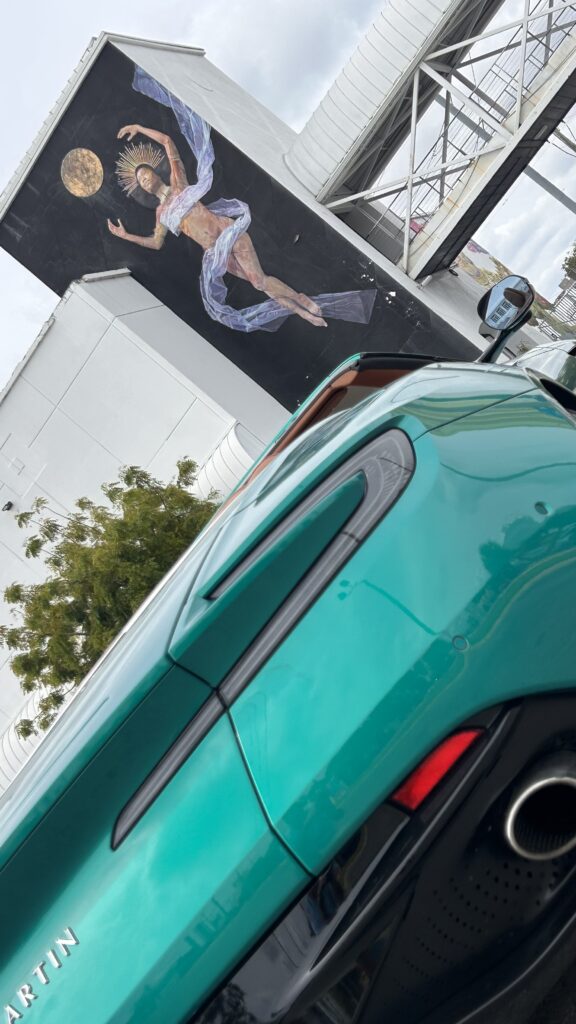 Aston Martin DB12 Volante luxury convertible photographed in Miami's Wynwood district, surrounded by vibrant street art and murals