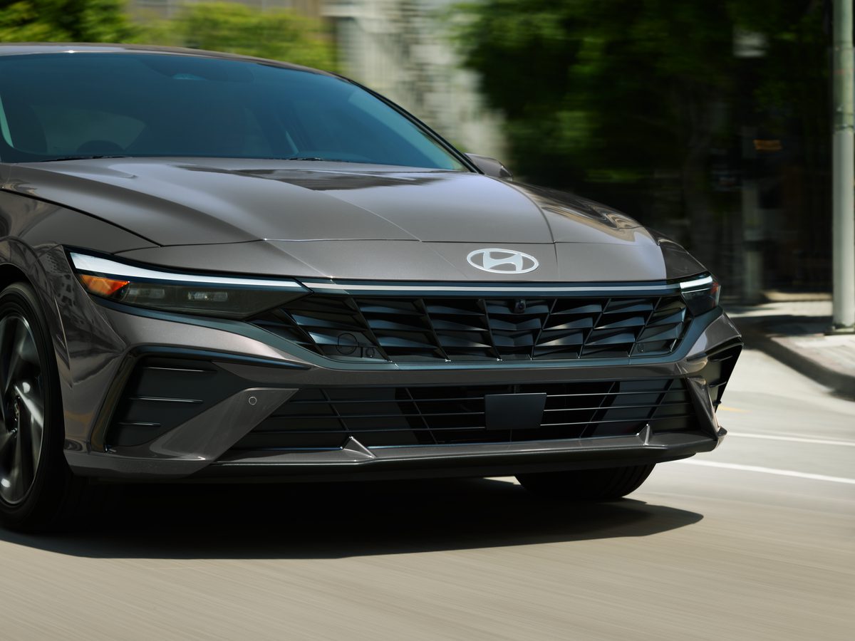 Close-up of a sleek gray car grille and headlight in motion.