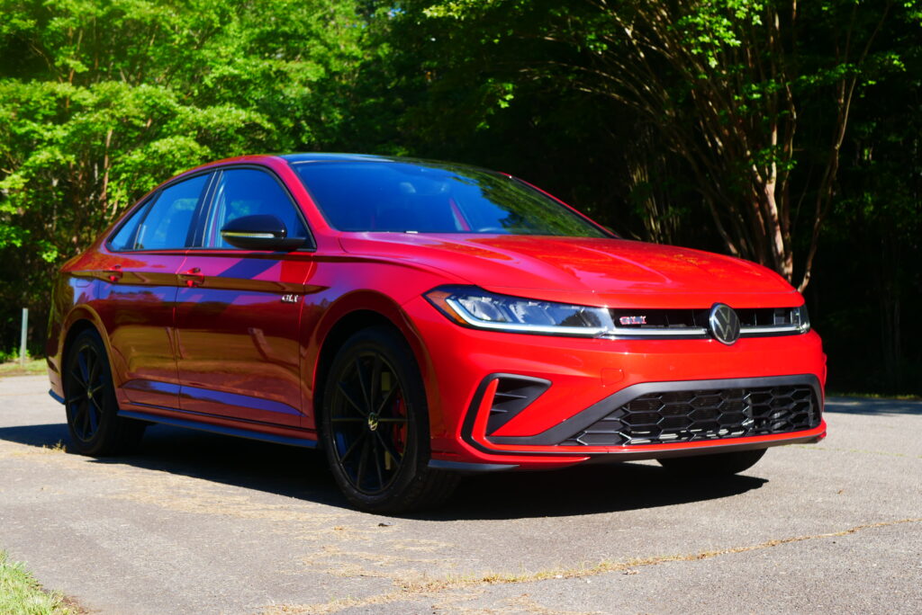 2025 Volkswagen Jetta GLI Autobahn sedan with sporty design, turbocharged engine, and premium features shown driving on city streets