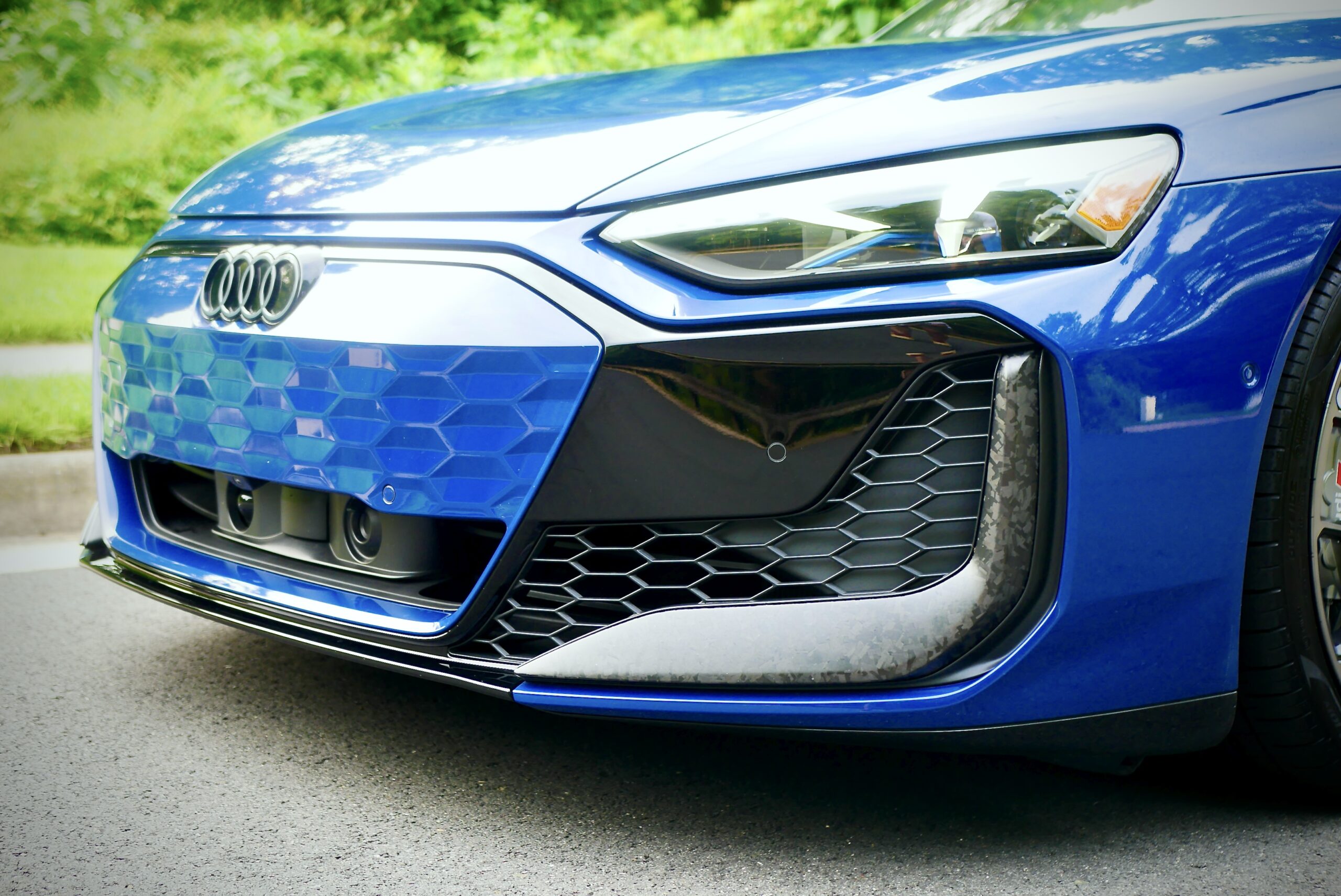 Close-up of a blue sports car front grille and headlight.