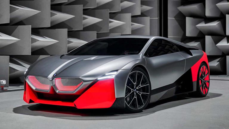 Futuristic silver sports car with red accents in a modern setting.