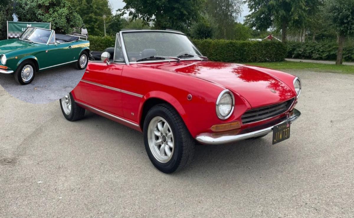Red vintage convertible car parked outdoors.
