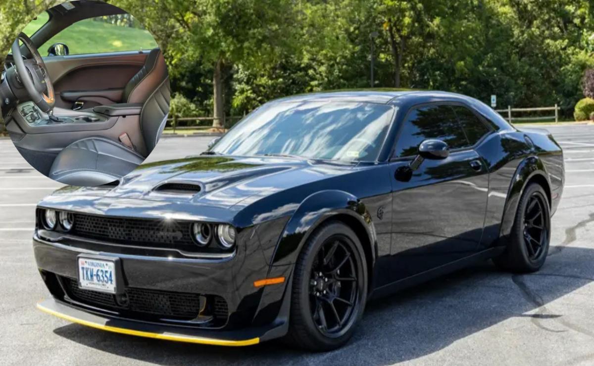 Black Dodge Challenger parked outdoors with tinted windows and custom wheels.