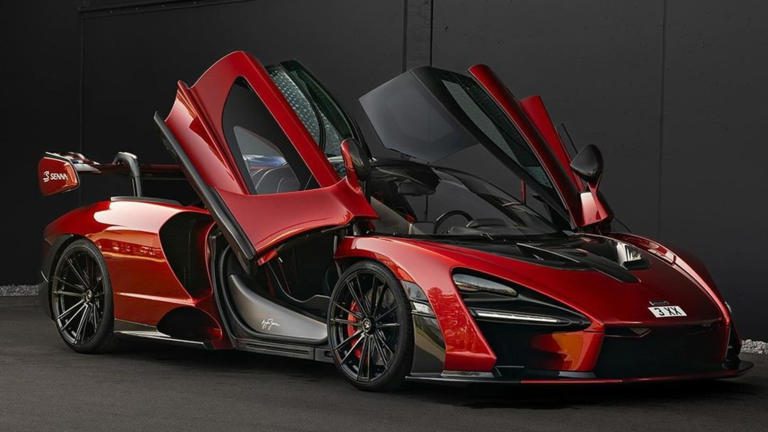 Sleek red sports car with butterfly doors open.