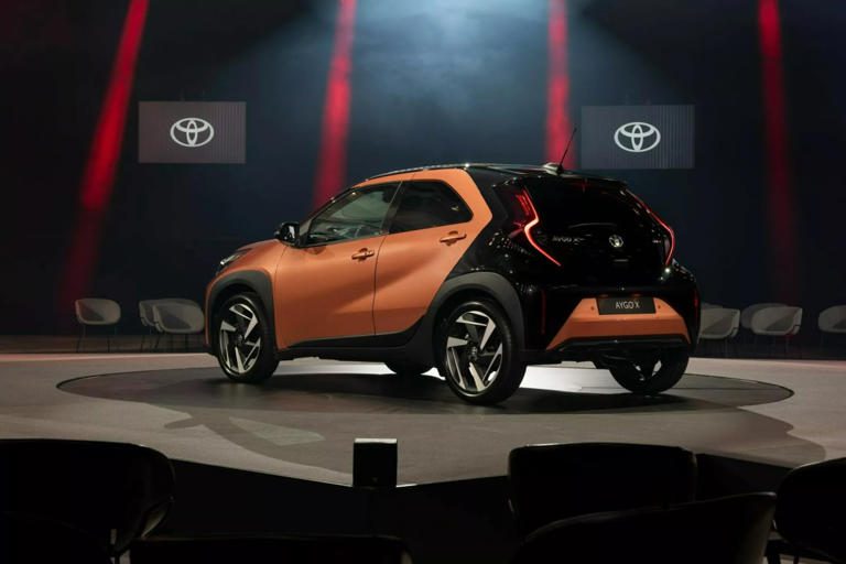 Sleek, modern Toyota car showcased under dramatic lighting on stage.