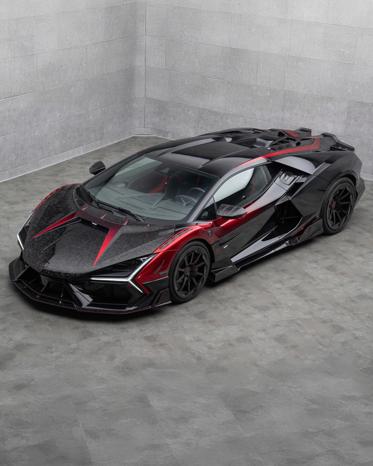 A sleek black and red sports car in a minimalist garage.