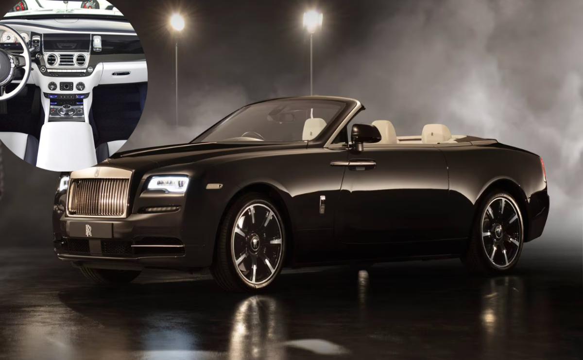 Sleek black convertible luxury car with beige interior in a dimly lit showroom.