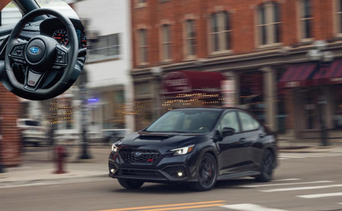 A sleek black car driving through a city street.