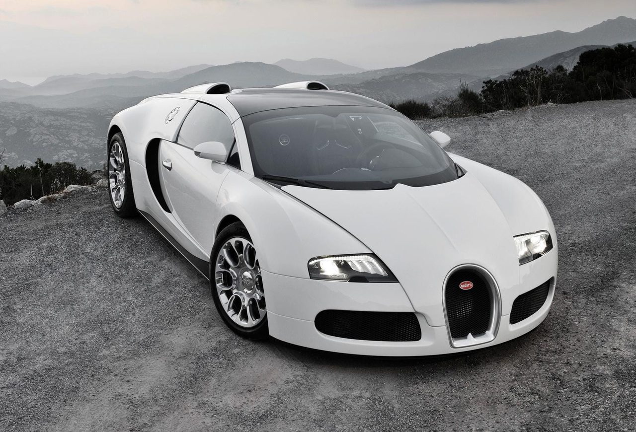 A sleek white Bugatti Veyron parked on a scenic mountain road.