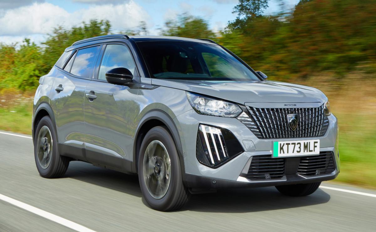 Silver Peugeot SUV driving on a highway with trees in the background.