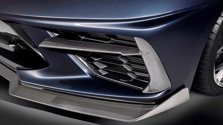 Close-up of a car's front grille with sleek black and chrome design.