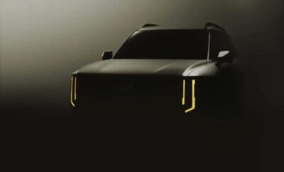A sleek black car with distinctive vertical LED headlights in a dim setting.