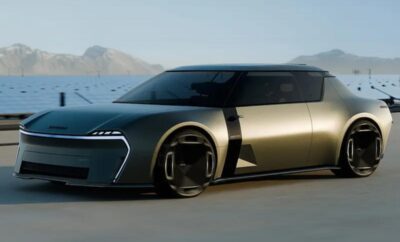 Futuristic concept car with sleek design by the water.