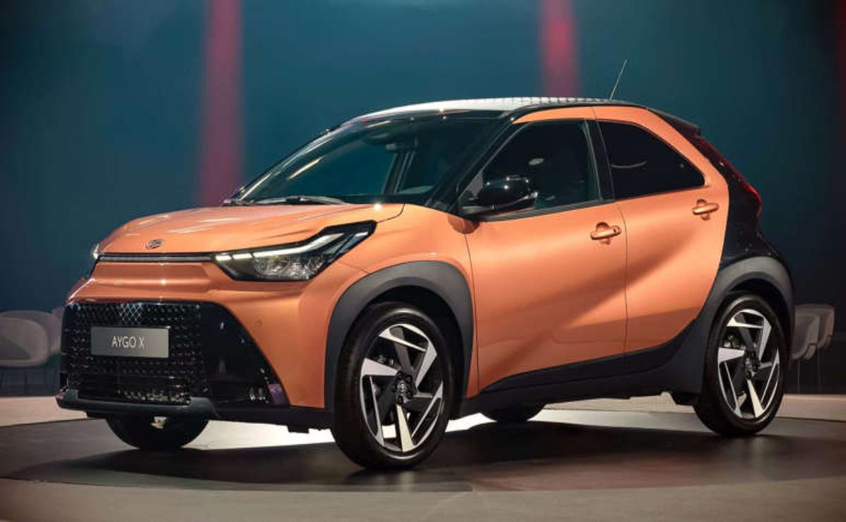 A sleek orange compact SUV with modern design features under showroom lighting.