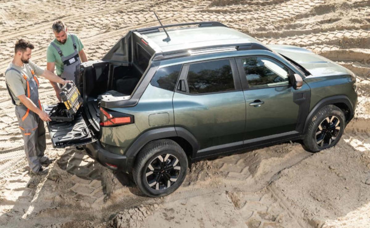 A green SUV stuck in deep sand with a person trying to free it.