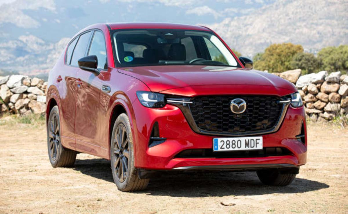Red Mazda SUV parked outdoors with mountainous background.