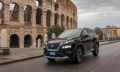 A sleek black SUV parked near an ancient Roman amphitheater under a cloudy sky.