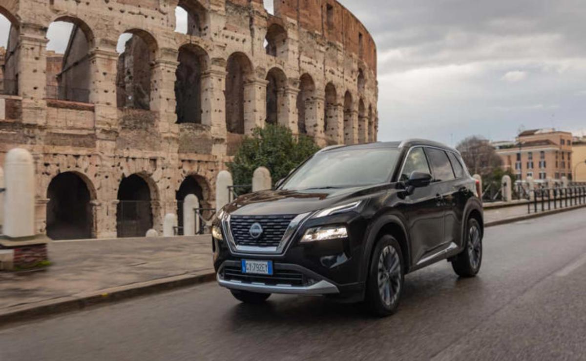 A sleek black SUV parked near an ancient Roman amphitheater under a cloudy sky.