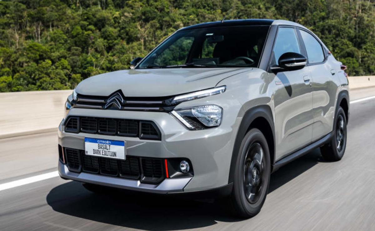 A silver Citroën SUV driving on a road with greenery in the background.
