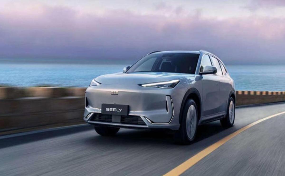 Sleek silver SUV driving along a coastal road with ocean views.