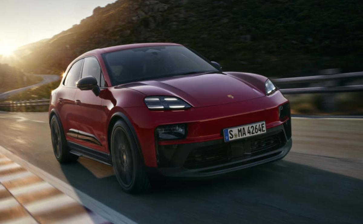 Red luxury SUV driving on a road at sunset.