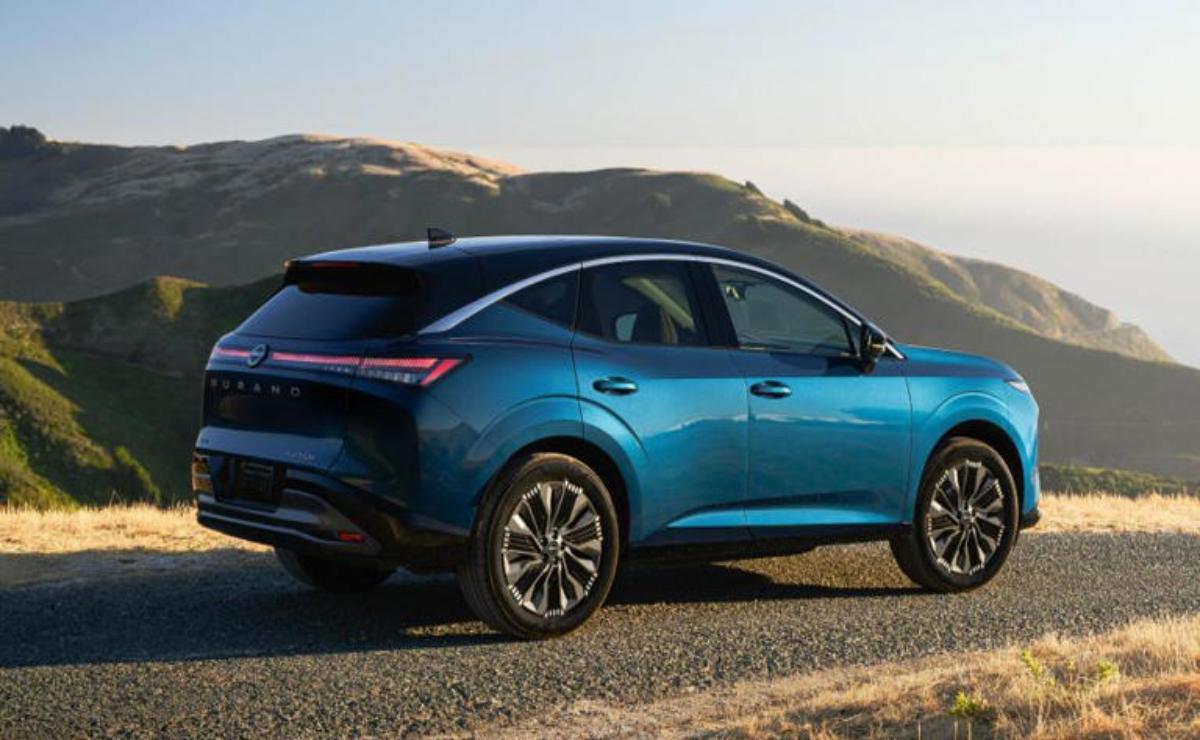 Blue electric SUV parked on a scenic mountain road during sunset.