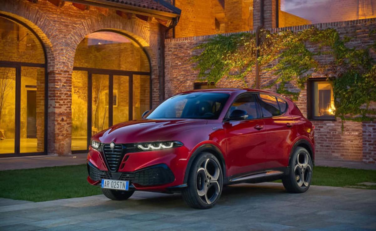 Red Alfa Romeo SUV parked in a charming courtyard at dusk.