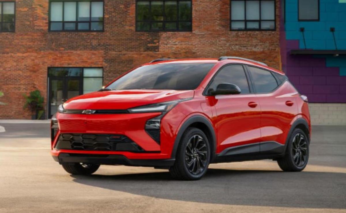 Red modern electric SUV parked in front of a brick building.