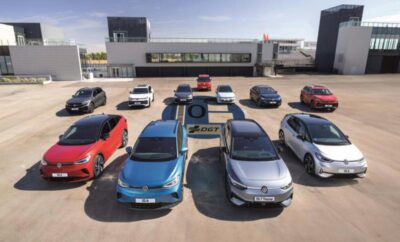 Electric cars charging at a station in a sunny parking lot.
