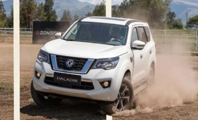 White Nissan Patrol SUV driving through dusty terrain.