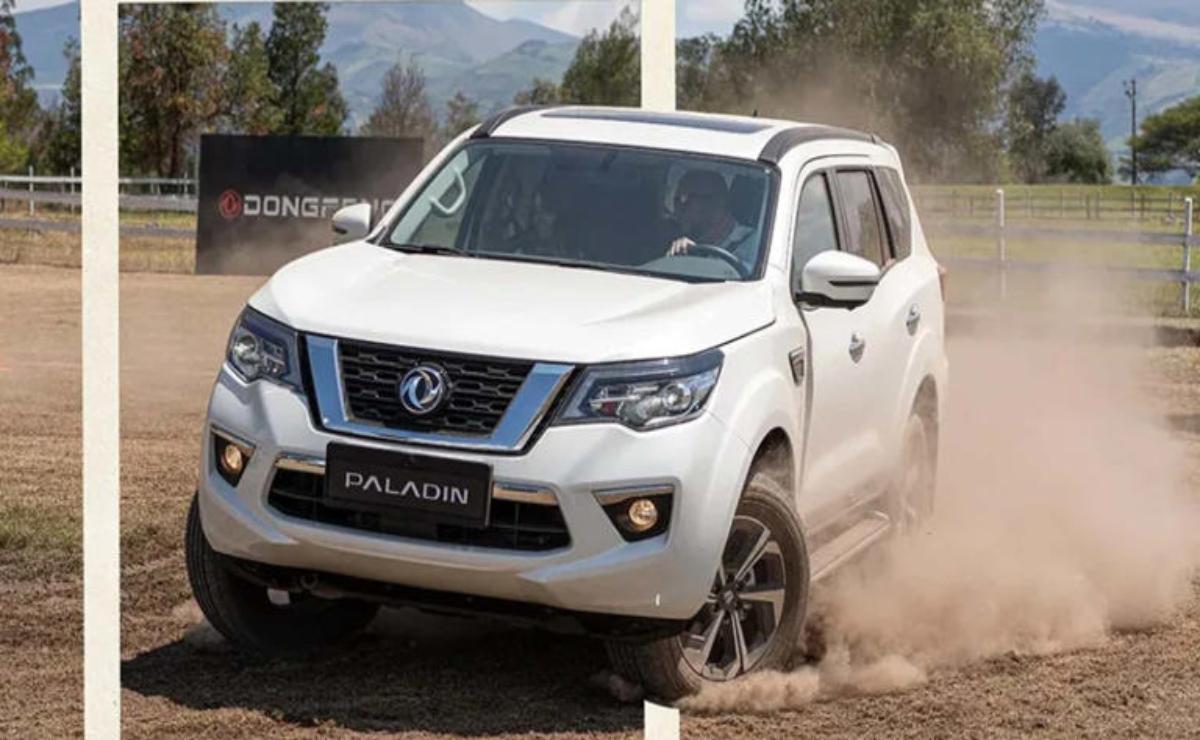 White Nissan Patrol SUV driving through dusty terrain.