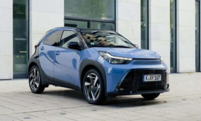 Sleek blue electric car parked near glass windows.