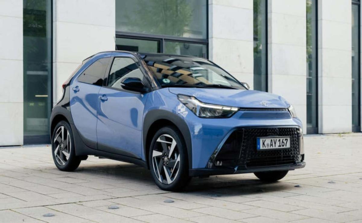 Sleek blue electric car parked near glass windows.