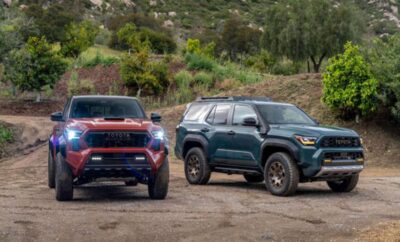 Two modern SUVs parked on a dirt path in a natural setting.