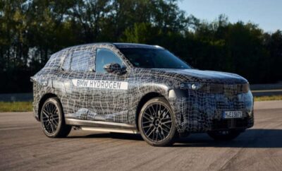 A camouflaged luxury SUV undergoing testing outdoors.
