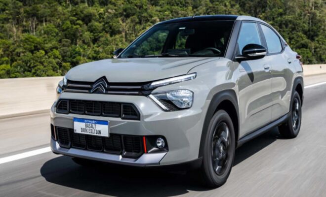A silver Citroën SUV driving on a road with greenery in the background.