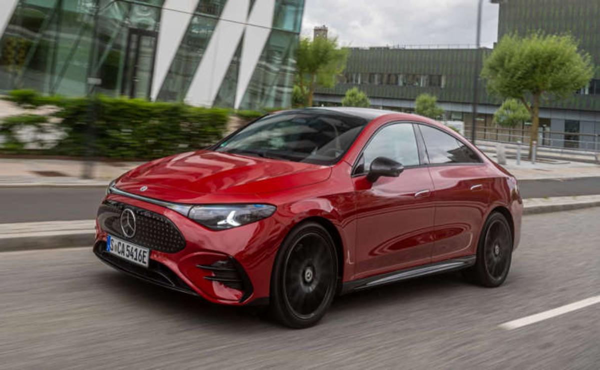 Red Mercedes-Benz CLA driving on a city road.