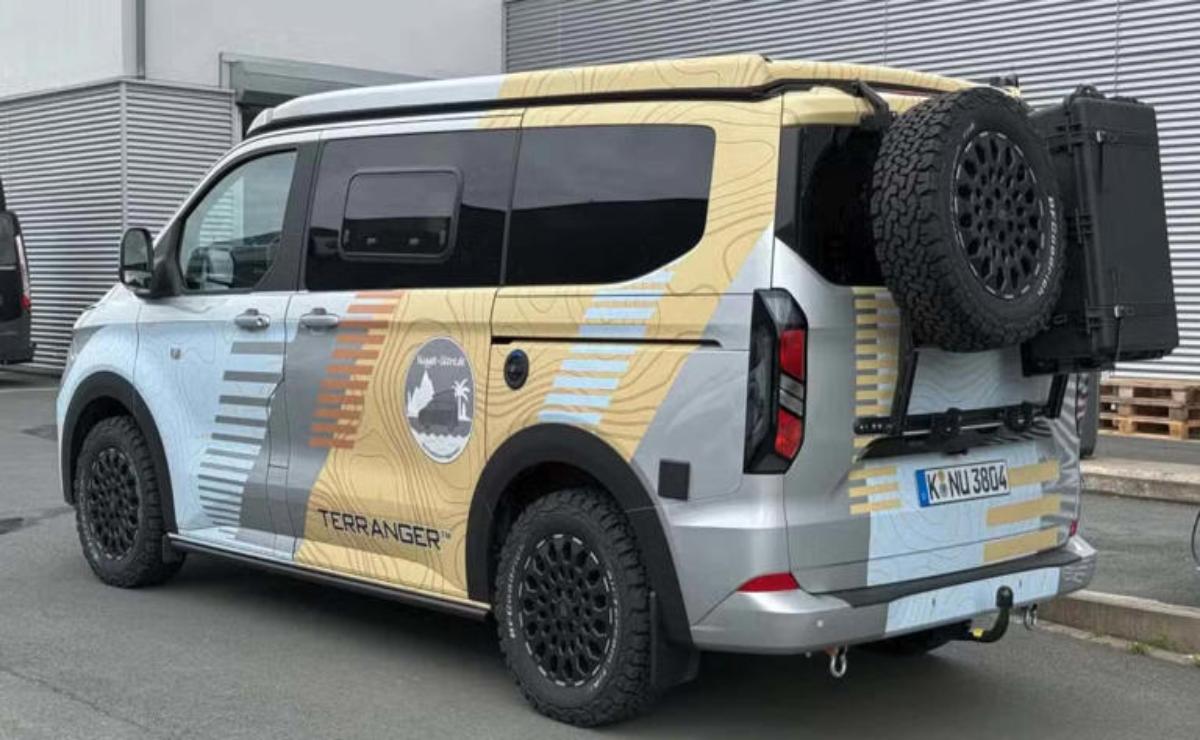 Custom van with distinctive beige and black design and large rear spare tire.