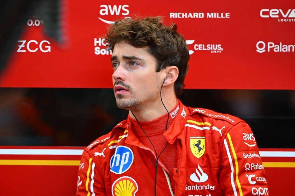 Charles Leclerc in Ferrari racing suit at an event.