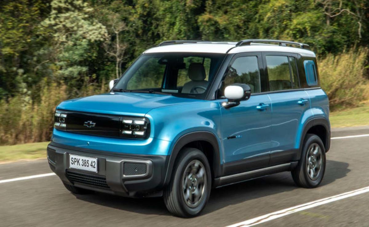 Blue compact SUV driving on a road surrounded by greenery.
