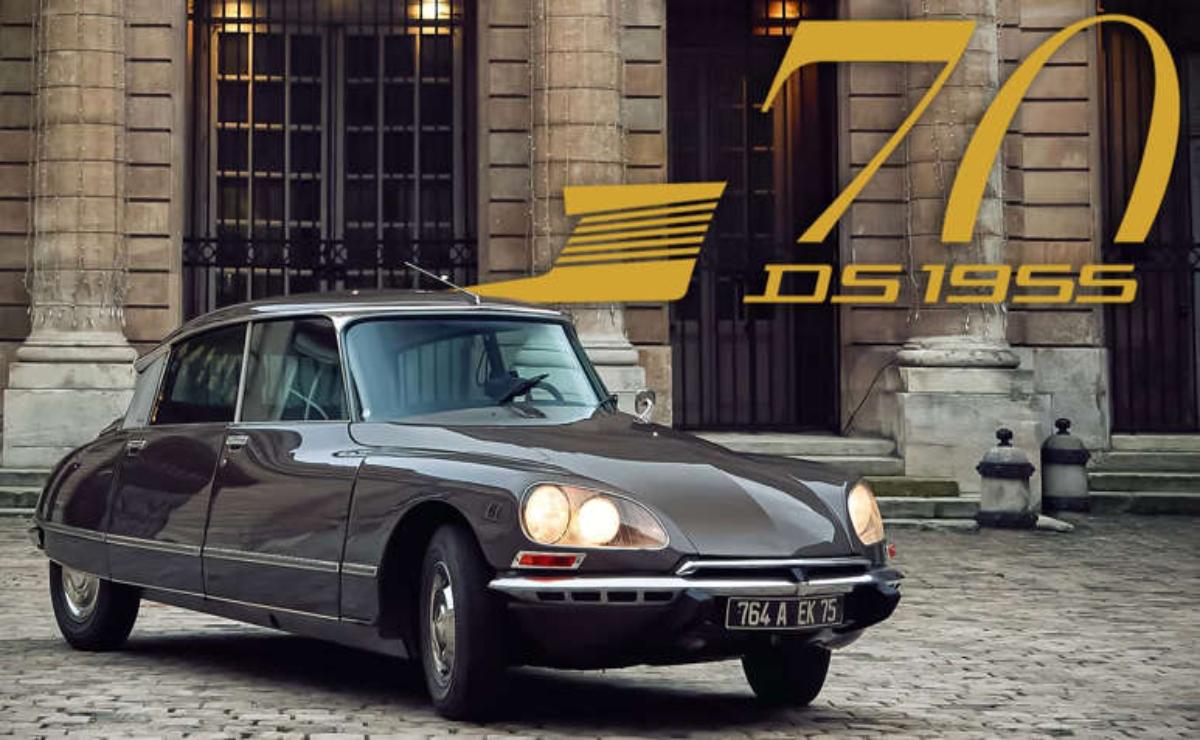 Classic Citroën DS 19 parked in front of a modern building at dusk.