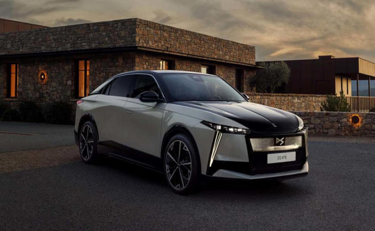 A sleek, modern silver and black electric car parked near a building at dusk.
