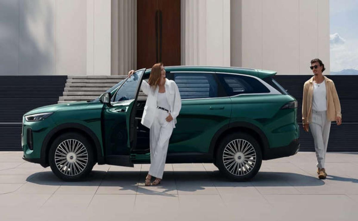 Woman in white outfit stepping out of a green luxury SUV.