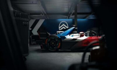Close-up of a sleek racing car in a dimly lit garage.