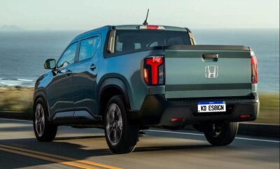 Rear view of a blue Honda pickup truck parked by the sea.