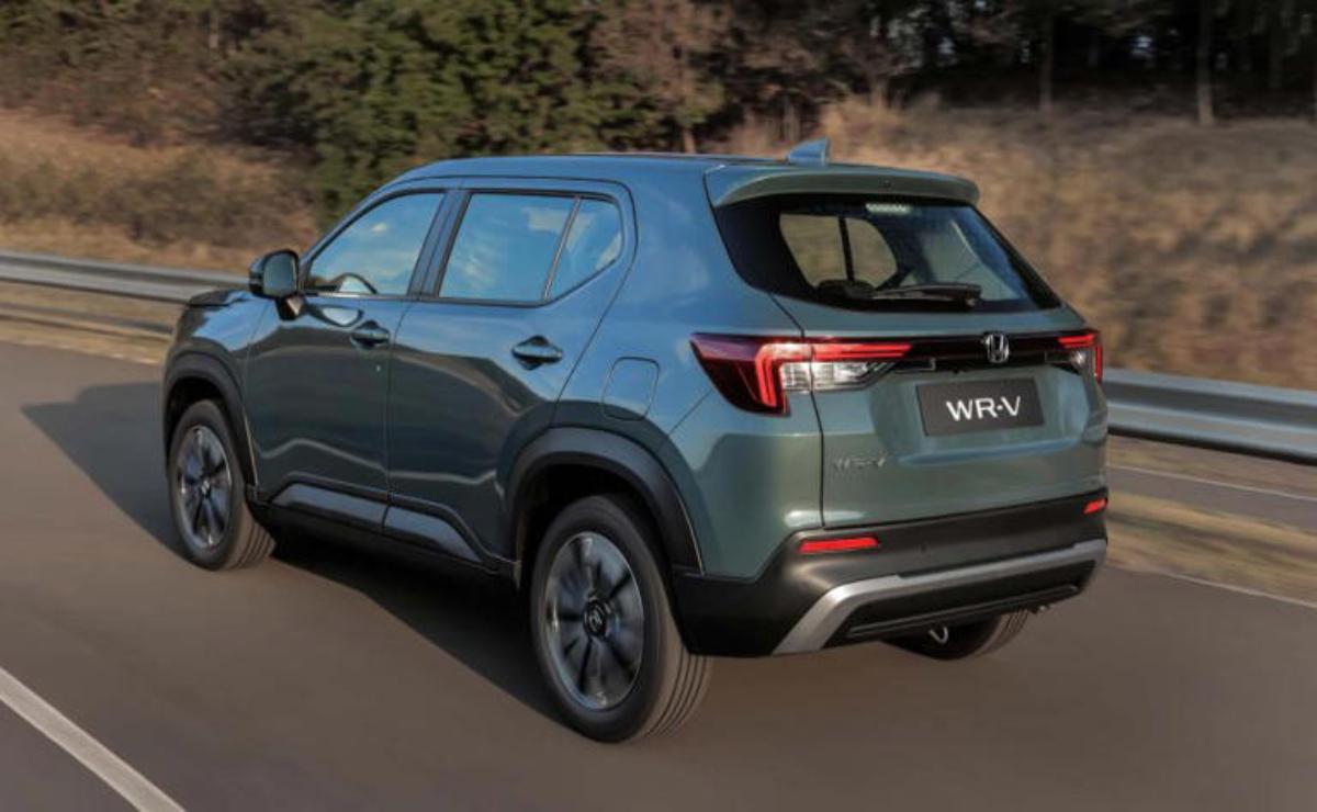 Sleek gray SUV driving on a suburban road surrounded by greenery.