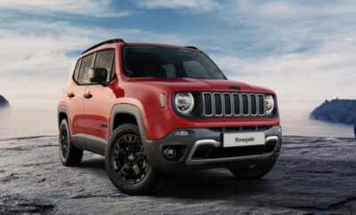 Red Jeep Renegade parked on a rocky terrain under a cloudy sky.